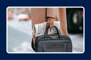 Photo of a hand holding a newspaper and work bag