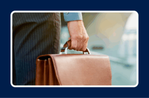 Close up shot of hand holding a tan briefcase