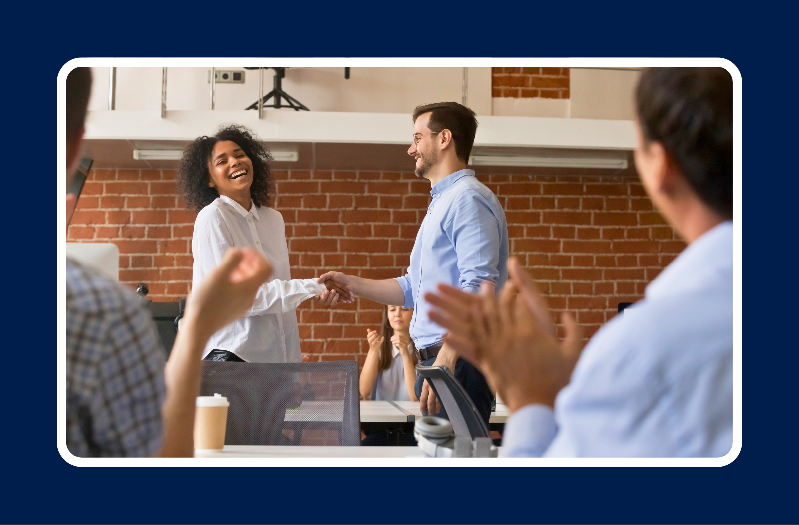 man shaking hands with woman to celebrate her receiving a promotion