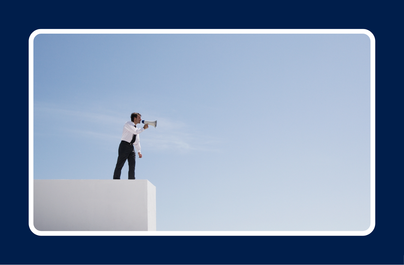 "Businessman standing on a white platform using a megaphone against a clear blue sky.