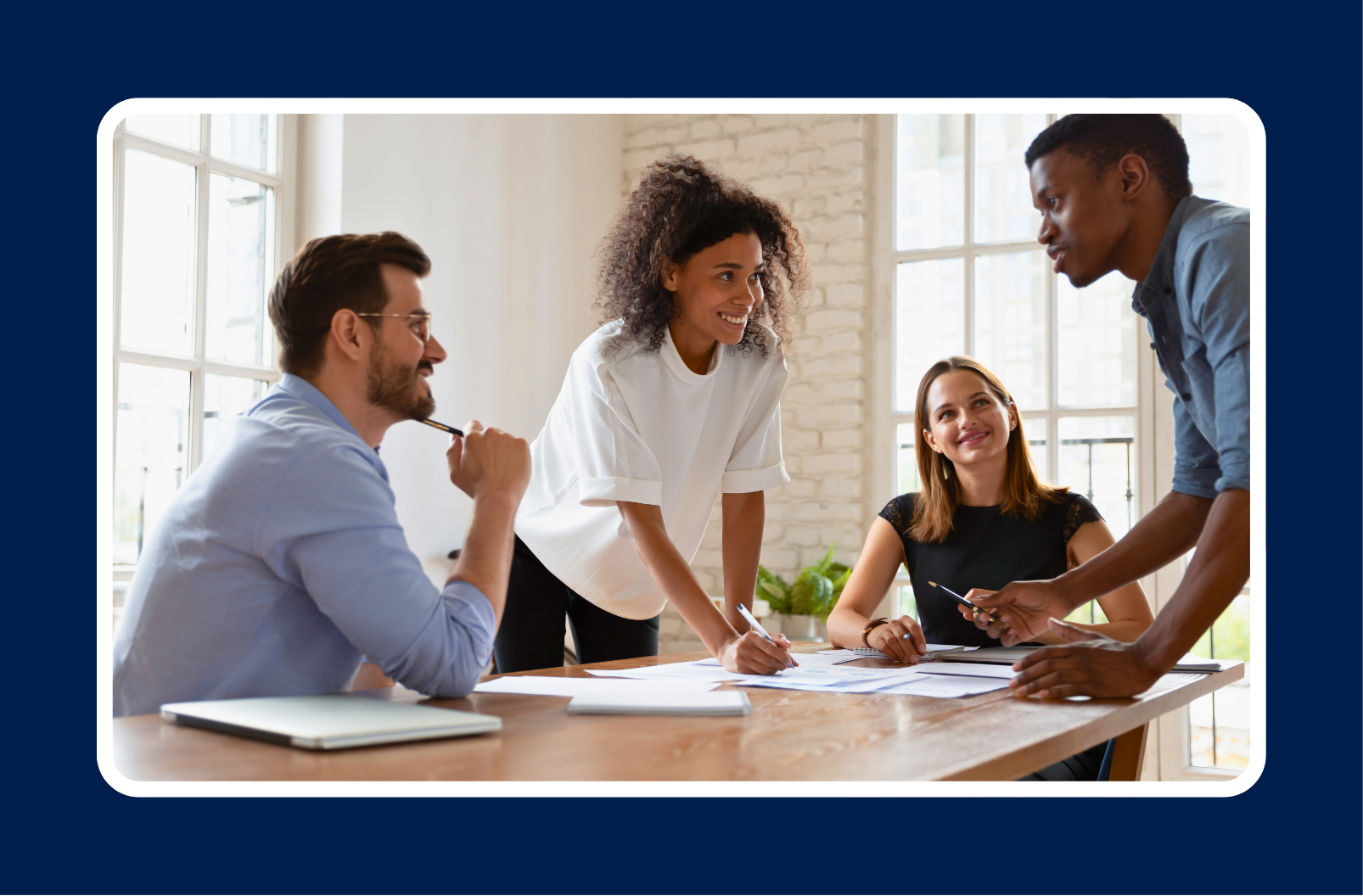 A diverse IT team collaborating around a conference table, highlighting essential soft skills in IT roles such as communication, teamwork, and problem-solving.