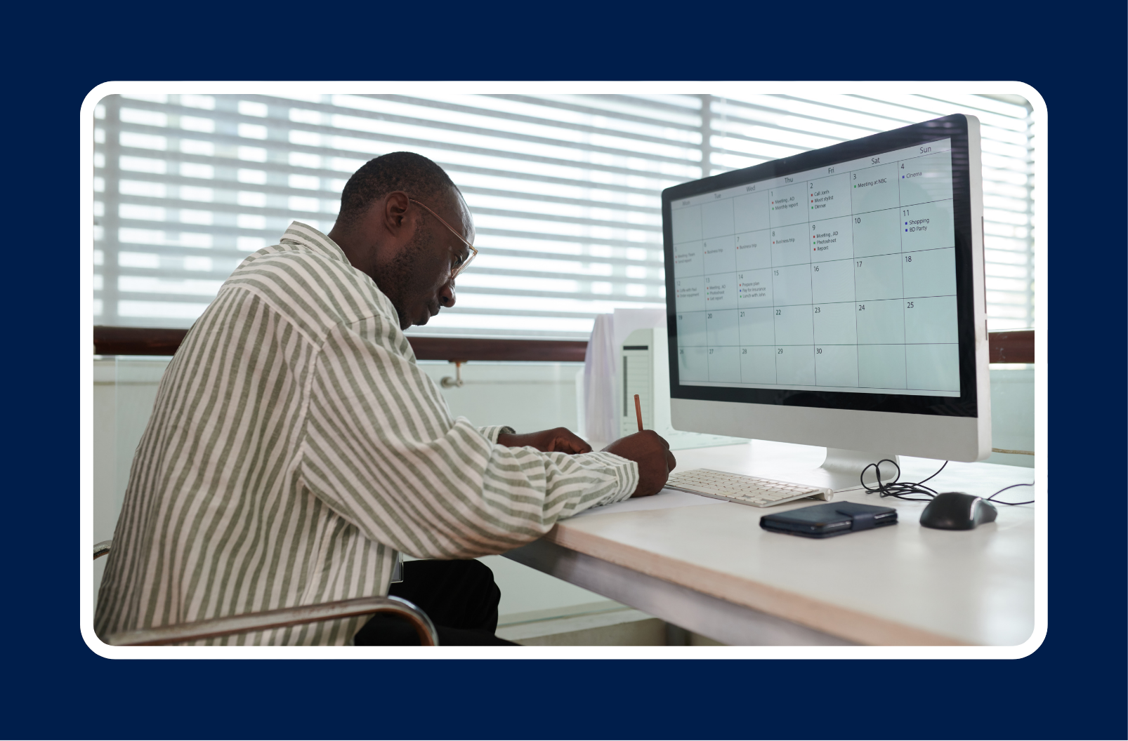 An executive planning the best work schedule for your team, reviewing a digital calendar on a computer while taking notes at a desk.