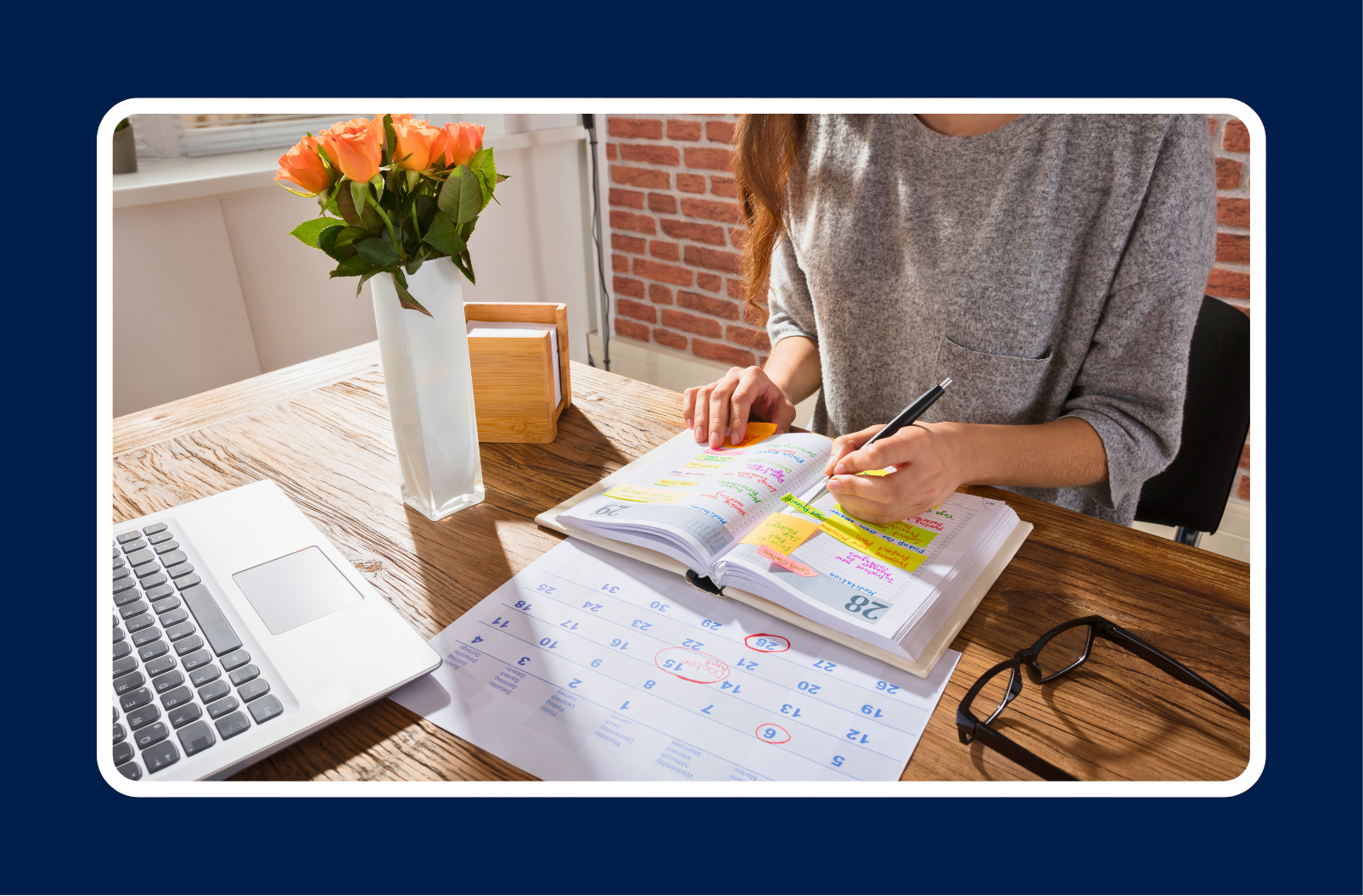 A hiring manager mapping out a 2026 hiring strategy at a desk with a laptop, calendar, and color-coded planner, highlighting key dates and workforce planning tasks.