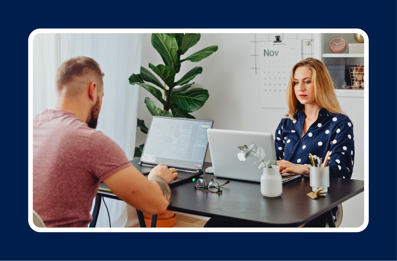 Two professionals working on laptops at a desk, representing collaboration and measuring developer productivity in a modern engineering team.