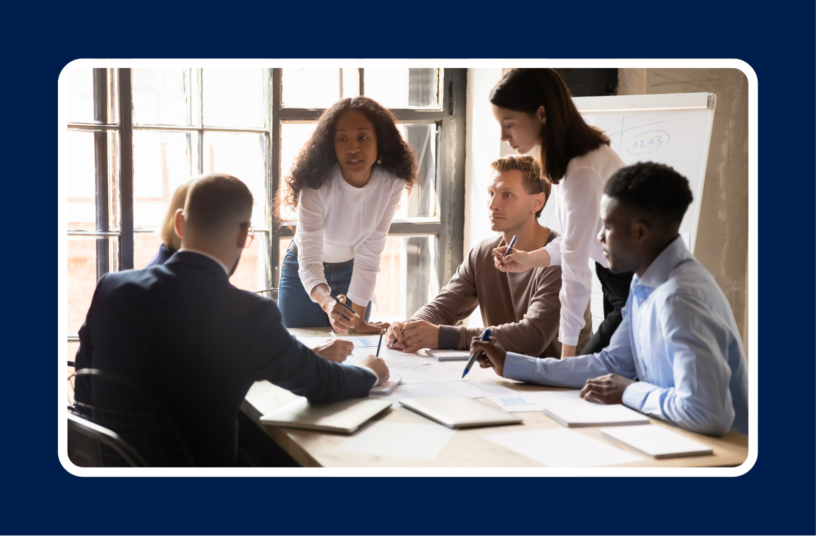 A team collaborating in a meeting, representing the transition from individual contributor to people leader through collaboration and shared decision-making.