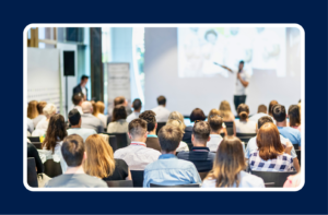 Conference audience listening to a speaker, illustrating personal branding for tech professionals through industry visibility and networking.