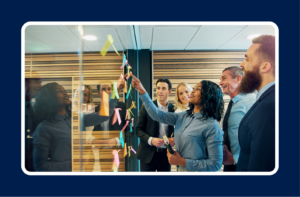 Team collaborating on a strategy board demonstrating cross-functional communication for technical leaders across engineering, product, and business teams.
