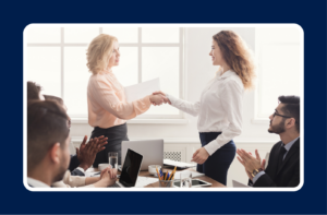 Professional woman receiving a job offer handshake in a conference room while colleagues applaud - representing an Internal Promotion vs External Job Offer decision