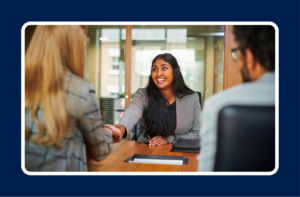 Job candidate shaking hands with hiring team during interview, representing learning how to turn interviews into job offers