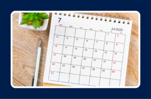 Mid-Year Career Review checklist with a July calendar, notebook, and pen on a wooden desk for career planning and goal setting.