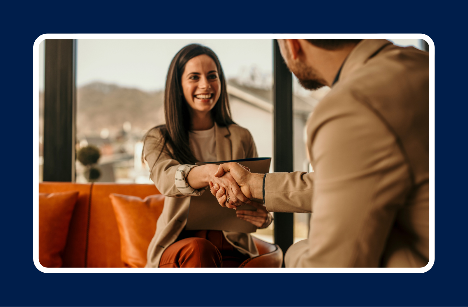 Candidate and hiring manager shaking hands during a job offer meeting, illustrating the questions to ask before accepting a job offer.