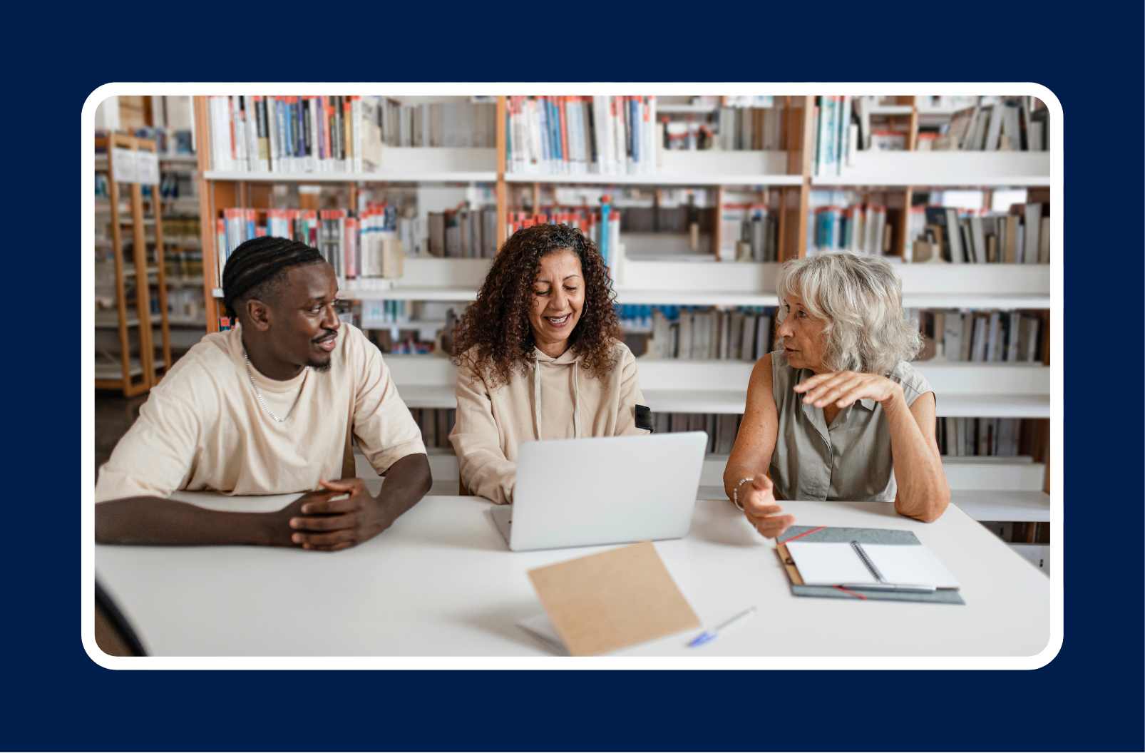 Three professionals collaborating around a laptop in a library, highlighting professional development and how to choose what skills to learn for career growth.